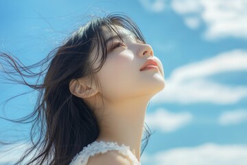 Poster - Beautiful woman smiling hair blowing in the wind blue sky background.