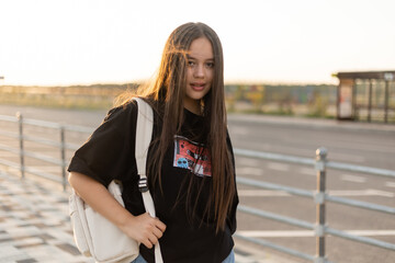 Teen girl with long hair at sunset in the city