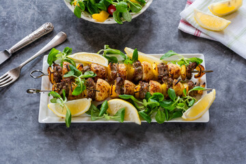 Wall Mural - Grilled lamb, yellow peppers and baby potato skewers with green leaf salad