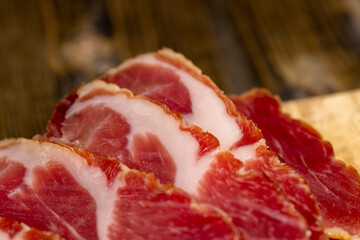 Wall Mural - a piece of cured pork ham with thin layers of lard on the table