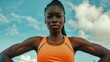 © Irina Ukrainets - Confident female athlete in orange sports attire posing outdoors against a bright sky. Fitness and empowerment concept. Ideal for sports, fitness, and motivational content. Created by AI.