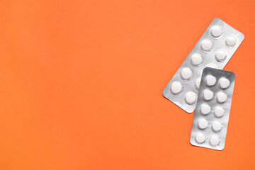 Wall Mural - Antibiotic pills in blisters on orange background, top view. Space for text