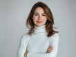 © Pixel Palette - Studio portrait of a young happy woman looking to the camera, light grey background, wearing a turtle neck