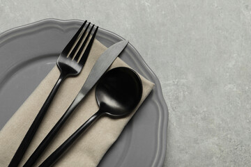 Wall Mural - Stylish cutlery, napkin and plate on grey table, top view. Space for text