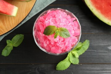 Wall Mural - Tasty watermelon sorbet with mint in glass dessert bowl on black wooden table, flat lay