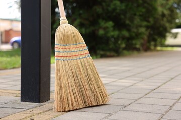 Wall Mural - One corn straw broom on pavement outdoors, space for text