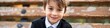 © The 2R Artificiality - Close up portrait of slim 8 year old school boy with patella alta wearing British prep school uniform sitting on a bench