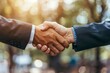 © Shutter2U - Two businessmen shaking hands in a park, symbolizing agreement and partnership.