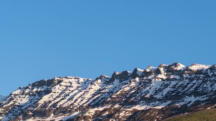 Wall Mural - 4K Time Lapse shot of the snowy Himalayan mountain peaks during the sunset turning red in colour from white during the sunset as seen from Keylong in Lahaul, Himachal Pradesh, India. Nature background