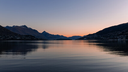 Sunset view of lake and mountains in Queenstown, New Zealand.