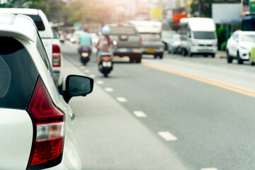 Wall Mural - Rear side view of white car on asphalt road. Transport of many cars driving on the asphalt road at day time in Thailand.