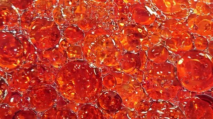 Canvas Print - Dynamic red and orange bubbles swirling in liquid