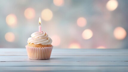 A single lit birthday candle on a cupcake, with a soft focus background providing space for birthday wishes. Commercial photography, Natural soft pale skin.