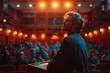 © Vilaysack - Speaker giving a presentation in a well-lit auditorium with an attentive audience in the background.