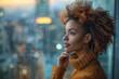 © Vilaysack - Thoughtful woman with curly hair gazing out of a window at an urban cityscape during twilight, wearing a cozy orange sweater.