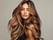 © Pravinrus - woman with luxurious, long hair styled in voluminous waves, displaying a seamless blend of hues from shatush and balayage coloring, with a serene expression and a simple,