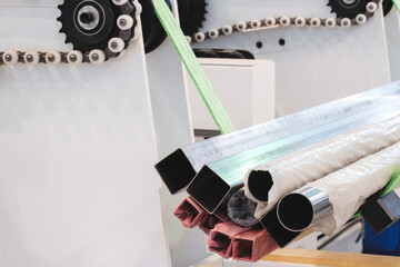 Poster - Industrial Machine holding a bunch of pipes. The pipes are of different colors and sizes. The machine is in factory settings. Industrial concept background