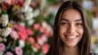 © EarthWalker - Young smiling cheerful woman florist at flower shop with vibrant flowers on blurred floral background