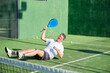 © Ladanifer - Happy mature man lying on court with paddle racket celebrating victory