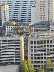 Wall Mural - Paris, France - April 12, 2024: Aerial view to the city of Paris, during the golden hour between modern skyscrapers and old buildings. Beautiful sunset over the city reflected on the buildings.