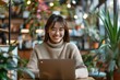 © Kevin - Happy businesswoman working remotely on laptop in a cozy cafe, Generative AI