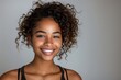 © Kevin - Happy young woman of color smiling at the camera in a studio, Generative AI