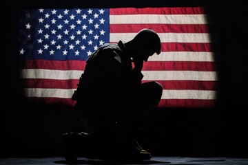 Silhouette of a Soldier Kneeling in Front of the American Flag