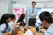 © InfiniteFlow - Project manager planning schedules for business task at meeting room, Gantt chart software show on TV screen. Multi ethnic diversity business people and modern business project management. Habiliment
