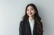 © Cosmic Edge - Smiling Young Professional Korean Woman with Long Hair in Business Attire Against White Background, Portrait Shot