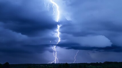 Wall Mural - Blinding bursts of light bursting through the churning angry clouds in the night sky.
