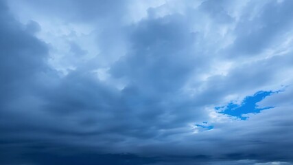 Wall Mural - The peaceful blue sky transformed into a churning sea of dark clouds as the cold front brings an icy blast of winter weather.