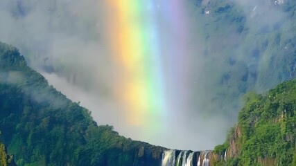 Wall Mural - a rainbow shining through the misty veil of the waterfall adding a touch of magic to the already enc