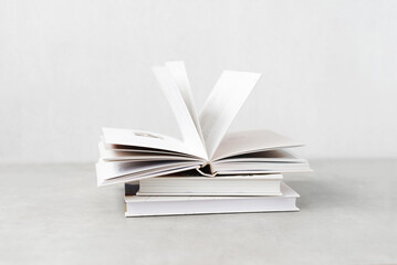 Stack of books with colorful bookbindings against white wall with copy space, Book Lover