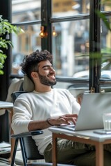 Sticker - A person sits at a desk with a laptop open in front of him, typing away