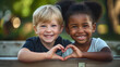 © Nemanja - Two little children or kids, Caucasian boy and African American girl happy smiling, making heart shape. Multiethnic multiracial diverse friends, diversity, different classmates together