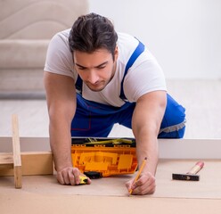 Wall Mural - Young male contractor installing furniture at home