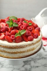 Wall Mural - Tasty sponge cake with fresh berries and mint on white marble table, closeup