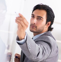 Wall Mural - Young handsome businessman in front of whiteboard