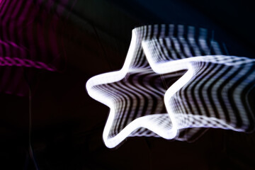Wall Mural - a star is lit up in a dark room. the star is white and has a black outline. the image has a dreamy, 