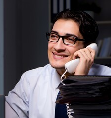 Wall Mural - Young businessman working overtime late in office