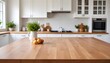 © Sharif54 - A wooden table top in the foreground with a blurred kitchen interior in the background, including white cabinets, a window, and some decorative item