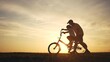 © maxximmm - Happy family. dad teaches his son to ride bike. happy family kid dream concept. silhouette of a child riding a bicycle. silhouette of a father teaching his son to ride lifestyle a bicycle.