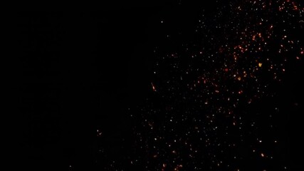 Wall Mural - a mesmerizing display of glowing sparks and particles, set against a dark backdrop, creating an ench