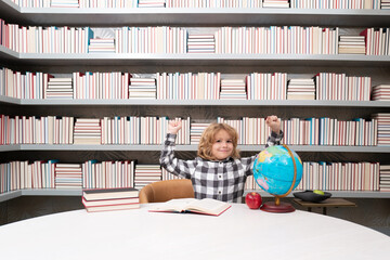 Fototapete - School and students in classroom. Education kids. Excited boy student in the school class. Studying and learning concept. School boy in the library near school supplies. Kid learn geography with globe