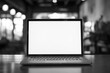© Viktor - Laptop on wooden desk with blank screen. Simple office setup with minimal clutter. Empty workspace for studying or working. Classic computer design on a rustic table.
