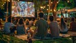 © liliyabatyrova - A group of people are sitting on a blanket in a park watching a movie