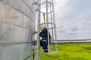 Wall Mural - Male worker climbs up the ladder inspection stainless tank