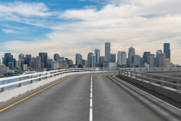 Elevated road curving towards a modern city skyline under a blue sky.