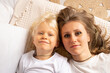 © Marharyta - Mother and her little child baby boy lying on bed at home. Child boy with strabismus eyes, squinting eyes, cross-eye. Motherhood, affection