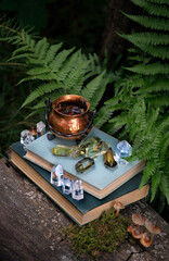 Sticker - witch cauldron, minerals and spell witch books in forest, natural background. Magic Crystal Ritual. Litho therapy. Witchcraft, spiritual esoteric practice. healing stone therapy for life balance